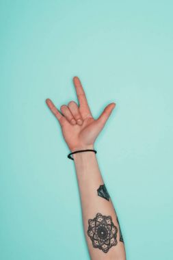 Turkuaz üzerinde izole rock işaret gösteren kadın kırpılmış atış