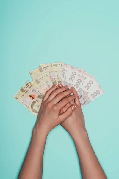 cropped shot of woman with bunch of cash isolated on turquoise