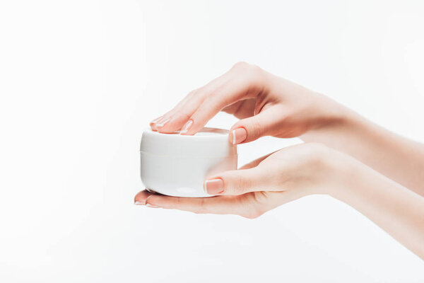 cropped shot of woman opening jar of anti-wrinkle cream isolated on white