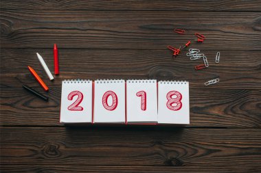 top view of 2018 calendar, pencils and stationery on wooden tabletop clipart