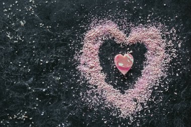 Üstten Görünüm pembe kalp şekilli sabun ve Siyah Mermer yüzey, spa konsept üzerine deniz tuzu