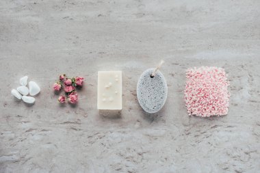 top view of stones, dried roses, natural soap, pumice and himalayan salt for spa on marble surface clipart