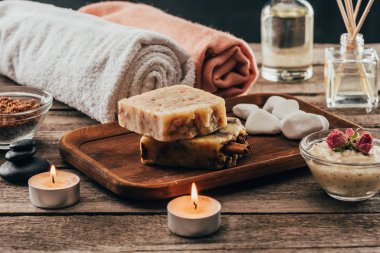 towels, homemade soap, spa treatment and candles on wooden tabletop clipart