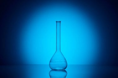 bir şeffaf cam şişeye tablo laboratuvar mavi üzerinde yansıtan üzerinde