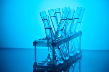 glass tubes with liquid on stand for chemical analysis on blue clipart