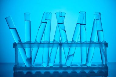 glass tubes with liquid on stand for scientific analysis on blue clipart