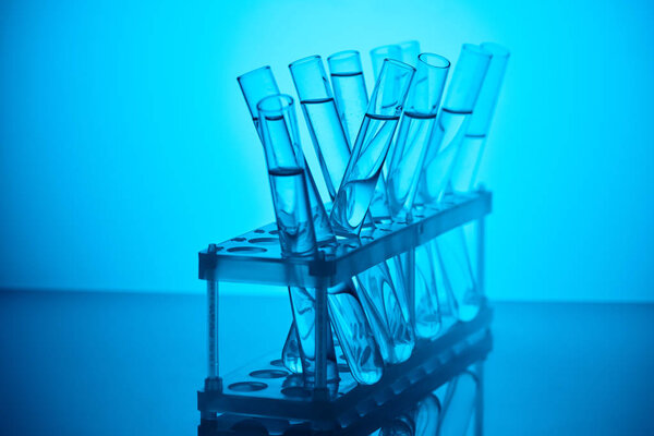 glass tubes with liquid on stand for chemical analysis on blue