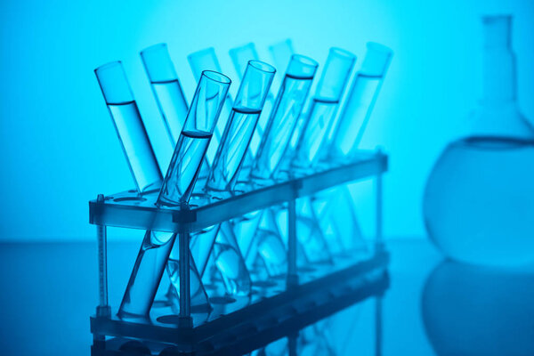 glass tubes with liquid on stand for chemical analysis in laboratory on blue