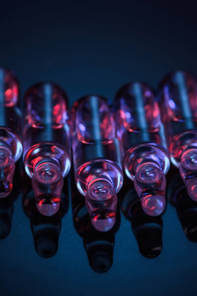 close up of transparent glass ampoules with liquid on table