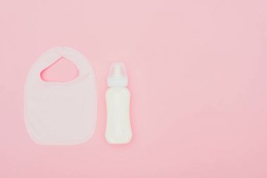Bebek önlük ve şişe süt pink izole Üstten Görünüm