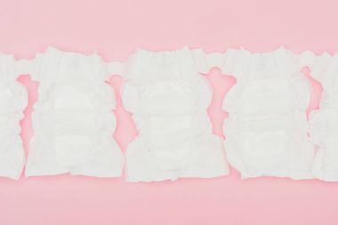 top view of clean unused baby diapers isolated on pink clipart