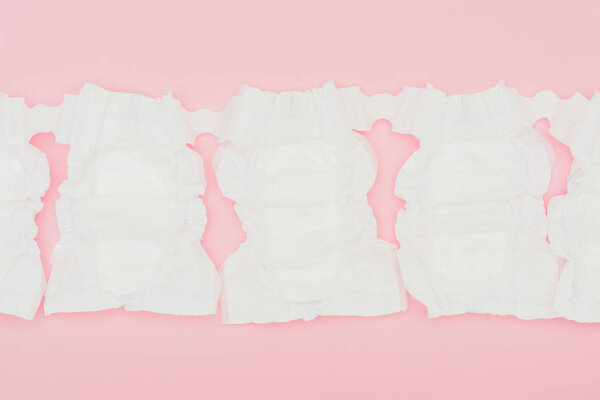 вид чистых неиспользованных подгузников, изолированных на розовом

