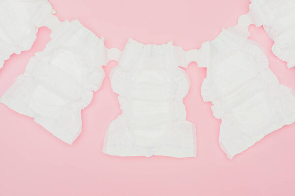 вид чистых неиспользованных подгузников, изолированных на розовом
