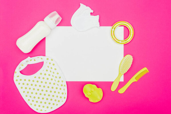 top view of empty board with baby accessories isolated on pink