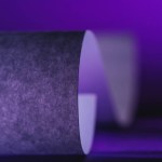 Nahaufnahme von grauem Papier auf violetter Oberfläche