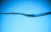 voda textura s kapkami, izolované na modré