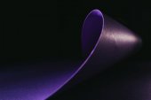 pokřivení fialový papír ve tvaru vlny na černém pozadí