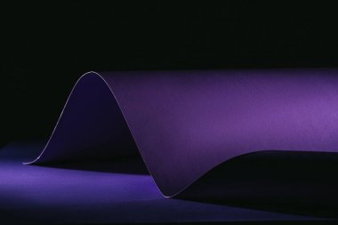warping purple paper on purple surface on black clipart