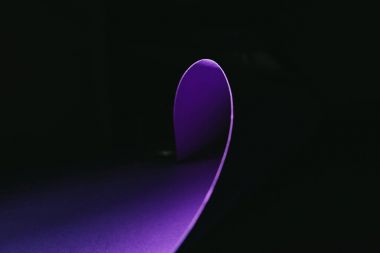 warping purple paper in shape of wave on black clipart