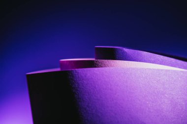 close up view of arcs of purple and pink paper on blue
