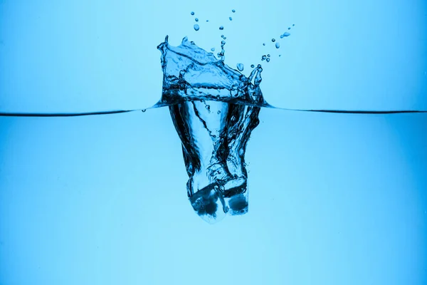 Cubo Hielo Salpicando Agua Aislado Azul — Foto de stock gratis