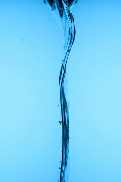 Versando Acqua Limpida Isolata Sul Blu — Foto stock gratuita