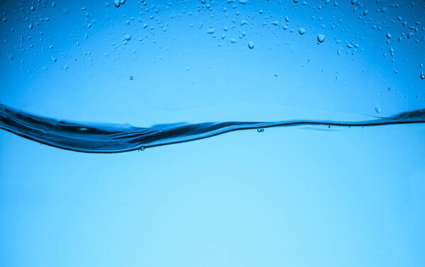 flowing water texture with drops, isolated on blue