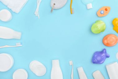 Pamuk temizleme bezi, diş fırçası, banyo oyuncakları, kozmetik krem ve losyon mavi izole şişelerde, kırpılmış görünümünü