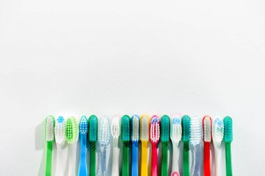 farklı renkli diş fırçaları, beyaz kopya alanı ile Tarih satırı