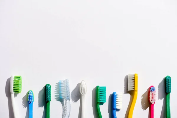 Linha Escovas Dentes Diferentes Branco Com Espaço Cópia — Fotografia de Stock