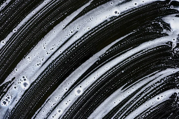 黒の表面に白い石鹸の泡のテクスチャ — ストック写真