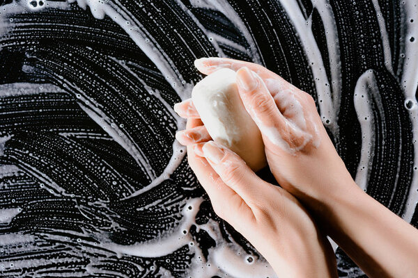 cropped view of woman washing hands with soap