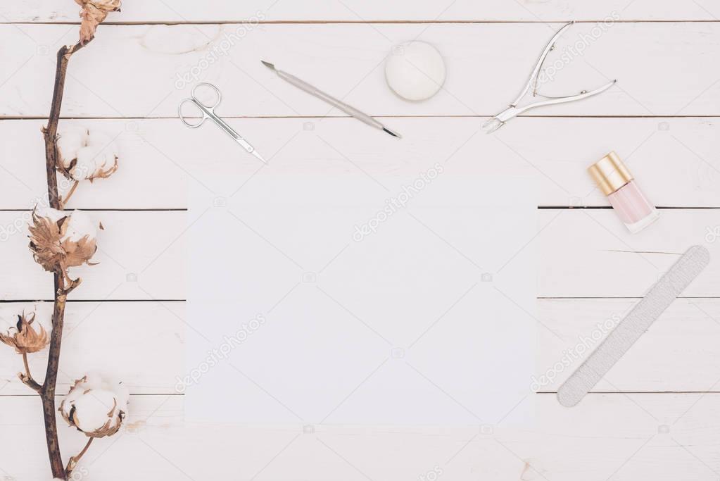 top view of manicure tools and white paper on wooden table