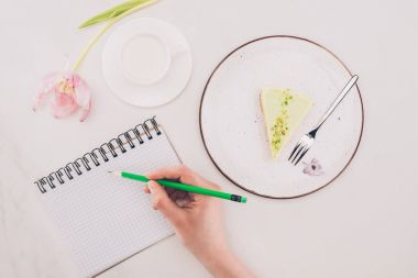 Notlar defter ile çok kolay ve süt tarafından fincan yapma kadın görüntüsünü kırpılmış