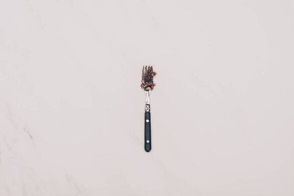 top view of fork with cake pieces isolated on grey