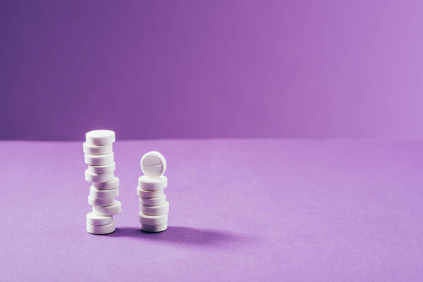 close up view of arranged pills on purple background 