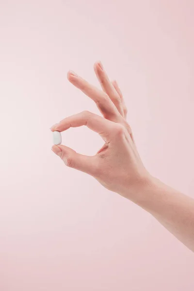 ピンクの分離の手で薬を保持している女性の部分的なビュー — ストック写真