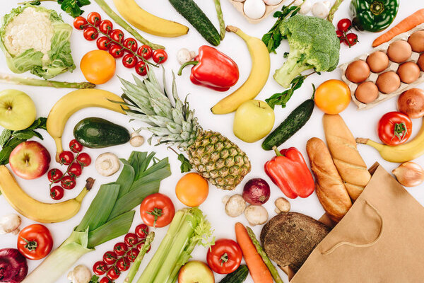 top view of vegetables and fruits and bread in shopping bag isolated on white, grocery concept