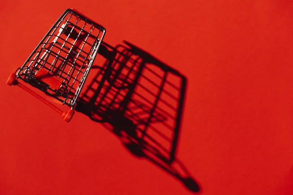 One Shopping Cart Shadow Red Wall — Stock Photo, Image