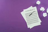 Ansicht des Geschäftsvertrags mit Stift auf violetter Oberfläche