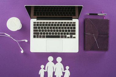 top view of business workplace with cut out family figures on purple surface, family insurance concept clipart