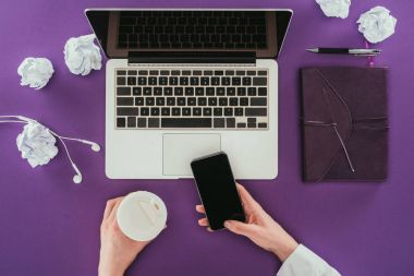 smartphone kullanarak ve mor yüzeyi işyerinde kahve içmek işkadını kırpılmış atış