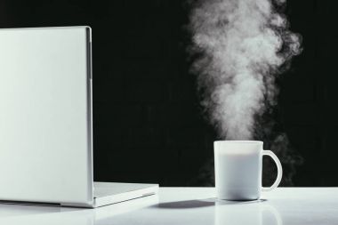 dumanı tüten fincan çay siyah izole tablo ile dizüstü bilgisayar