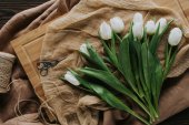 pohled shora na bílé jarní tulipány na dřevěné desce pro mezinárodní Dámské den