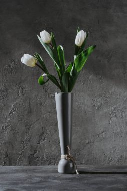 beton yüzeyi gri Vazoda beyaz bahar laleler