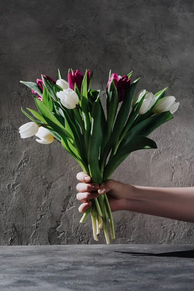 Обрезанный Вид Женщины Держащей Весенние Тюльпаны Серой Поверхности — стоковое фото