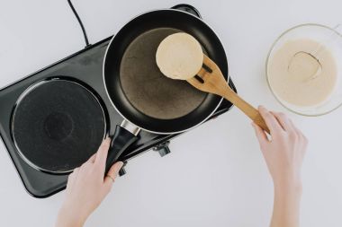 top view of person cooking pancakes on frying pan on grey clipart