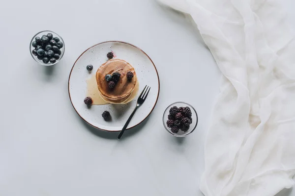 Bovenaanzicht Van Lekkere Huisgemaakte Pannenkoeken Met Honing Verse Bessen Grijs — Gratis stockfoto