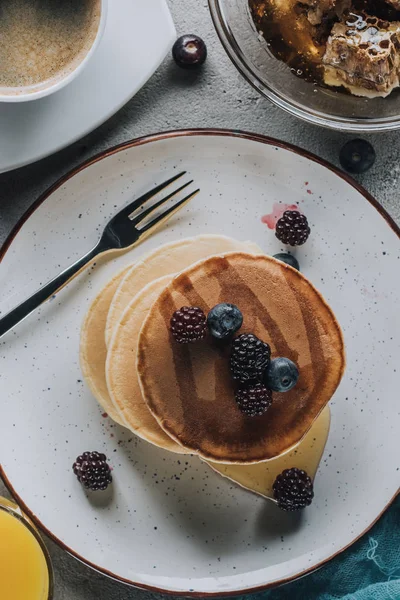 Von Oben Auf Süße Hausgemachte Pfannkuchen Mit Beeren Und Honig — kostenloses Stockfoto