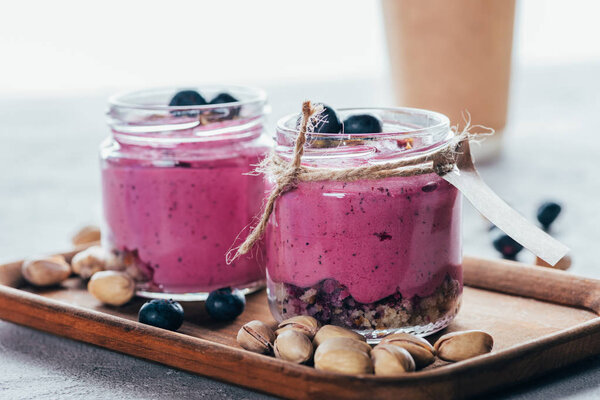 close-up view of healthy gourmet pink smoothie with granola, nuts and berries 